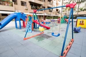 un parque infantil con equipo de juegos colorido frente a un edificio en Localização privilegiada na Barra da Tijuca RJ, en Río de Janeiro