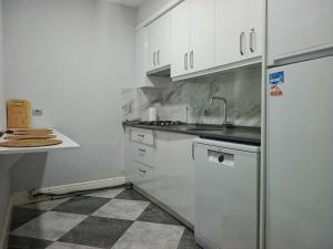 a kitchen with white cabinets and a refrigerator at Fethiye central big apartment in Fethiye
