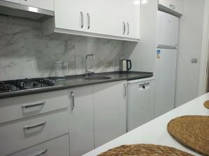 een keuken met witte kasten en een spoelbak bij Fethiye central big apartment in Fethiye +7 foto's