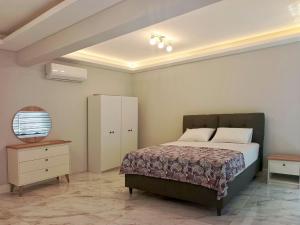 een slaapkamer met een bed, een dressoir en een nachtkastje bij Fethiye central big apartment in Fethiye