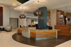 an office lobby with a reception desk and chandeliers at Hyatt Place Manati in Manati