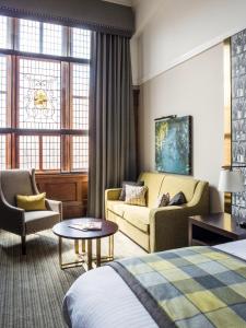 um quarto de hotel com uma cama, um sofá e uma mesa em ABode Glasgow em Glasgow