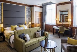 una camera d'albergo con letto e divano di ABode Glasgow a Glasgow