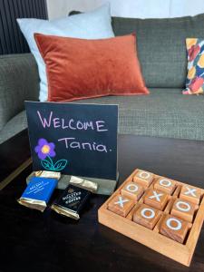 a table with a welcome to taipei sign and a box of chocolateuts at Harbour Hideaway in Dunedin