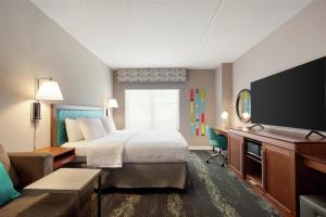 a hotel room with a bed and a flat screen tv at Hampton Inn at Tin Lizzie Gaming Resort in Deadwood