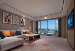 un soggiorno con un divano e una TV di Howard Johnson Airport Hotel Changsha a Changsha