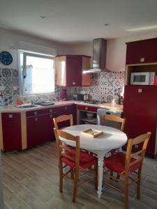 a kitchen with a white table and chairs and a sink at le ch'ti 4 saisons Maison de vacances avec parking et jardin in Saint-Omer