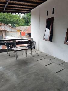two chairs and a table sitting on a patio at Thousands of Bottles - Hostel and Trekking in Bukit Lawang
