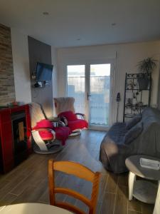 sala de estar con sofá, cama y chimenea en le ch'ti 4 saisons Maison de vacances avec parking et jardin, en Saint-Omer