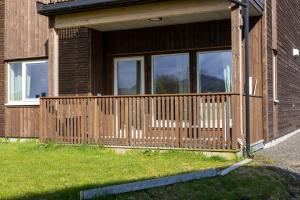 a house with a wooden deck on the side of it at Leknestunet in Vestvågøya