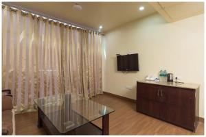 a living room with a glass table and a television at A Premium Hotel FAIRWAY Near Railway Station - Well Decorated & Spacious Rooms - Lift # Restaurant # Free Parking And Free Wi-fi Available - A Top Rated Hotel In Amritsar in Amritsar