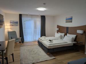 a hotel room with a bed and a table and chairs at Turmhotel Scharbeutz in Scharbeutz +6 photos