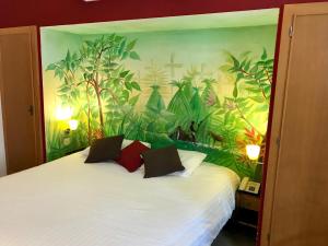 a bedroom with a bed with a mural of plants at Le Windsor, Jungle Art Hotel in Nice