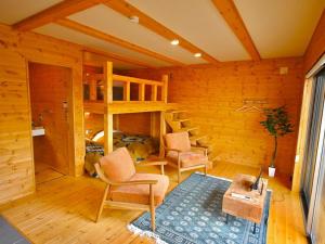 a room with a bunk bed and a chair and a table at Kosugi Resort in Aso