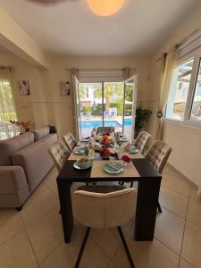 a dining room with a table and chairs at Villa Eden Palms, Coral-Bay, Pool in Peyia +114 photos