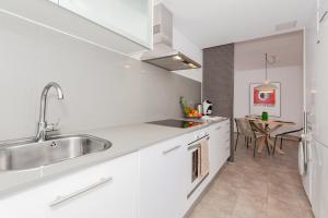 Boutique apartament في ثيوداديلا: مطبخ أبيض مع حوض وطاولة