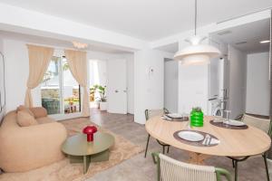 Boutique apartament في ثيوداديلا: غرفة معيشة مع طاولتين وأريكة +7 صور