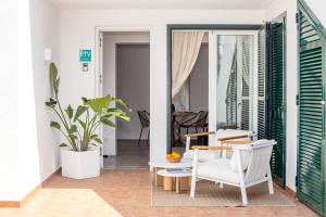 Boutique apartament في ثيوداديلا: غرفة معيشة بها طاولة وكراسي