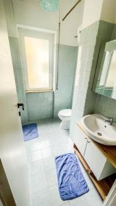 a bathroom with a sink and a toilet and a window at Gumantu Stay in Praia a Mare