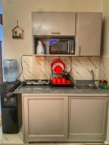 eine Küche mit Spüle und Mikrowelle in der Unterkunft Studio Carmen with a Pool View in El-Alamein