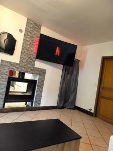ein Wohnzimmer mit einem TV und einem Kamin in der Unterkunft Maison de village in La Motte-en-Beauges