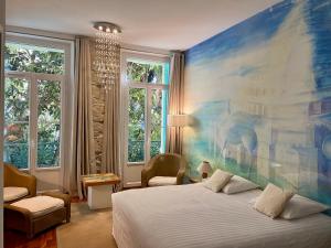 a bedroom with a large painting on the wall at Le Windsor, Jungle Art Hotel in Nice
