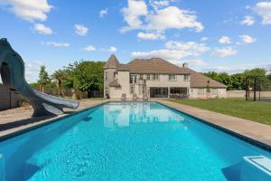 a swimming pool with a slide in front of a house at The Country House home in Hurricane
