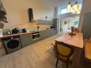 a kitchen with a wooden table and a dining room at Appartement, terrasse de plain-pied in Plounéventer