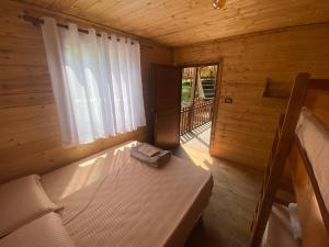 a small room with a bed in a wooden cabin at Captain's House in Mollʼ e Shoshit