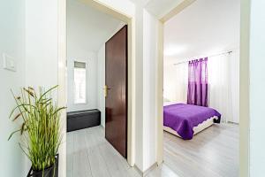a bedroom with a purple bed and a window at Apartment Doris in Vela Luka