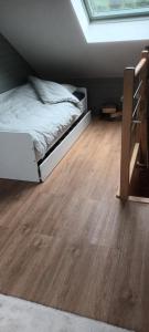 a bedroom with a bed and a wooden floor at G mi cabaña in La Celle-sous-Gouzon