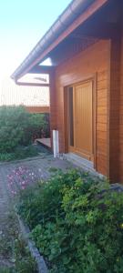 a building with a door and a yard with flowers at G mi cabaña in La Celle-sous-Gouzon