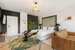 a bedroom with a bed and a couch at Molo Luxury Suites Puerto Banus in Marbella
