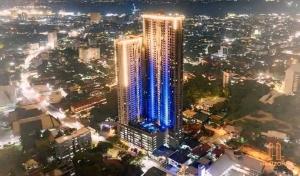 a tall building with blue lights in a city at night at Horizon 101 in Sampong +3 photos