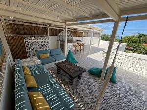 eine Terrasse mit einem blauen Sofa und einem Tisch in der Unterkunft Villa Ben Uluwatu in Uluwatu