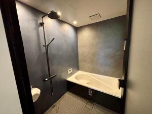a bathroom with a bath tub and a sink at Kinagashi Happo Chalet West in Hakuba +40 photos