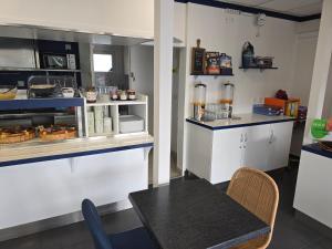 a small kitchen with a table and a counter at Brit Hotel Essentiel Poitiers Gare du Futuroscope in Jaunay-Clan
