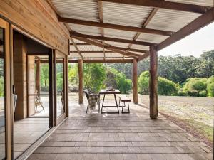 eine Terrasse mit einem Tisch und Stühlen darauf in der Unterkunft Marima Cottages in Pemberton