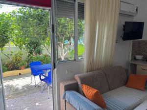a living room with a couch and a sliding glass door at Apartments Rudi in Orikum