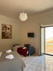 a bedroom with two beds and a television and a chandelier at Le Muse apartment in Caserta