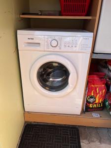Eine Waschmaschine und ein Trockner stehen auf einem Regal. in der Unterkunft E.A.MINIKAMP in Lelle