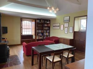 a living room with a red couch and a table at Apartamento Memória in Angra do Heroísmo