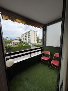 a balcony with two red chairs and a window at Chez Geremio - T4 - Centre Ville in Annecy