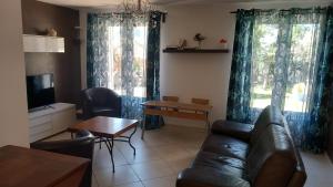 a living room with a couch and a table at La quiétude de St Antoine - piscine privée in LʼIsle-sur-la-Sorgue