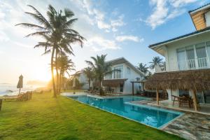 a villa with a swimming pool next to the ocean at KUKI BEACH - Luxury Beachfront Villa in Ahangama in Ahangama
