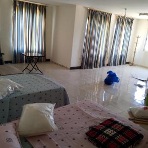 亚喀巴New Room的一间卧室，地板上有两张床和一个蓝色的袋子