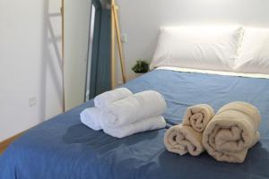 a group of towels and towels on a bed at Nanni's House in Quartu SantʼElena