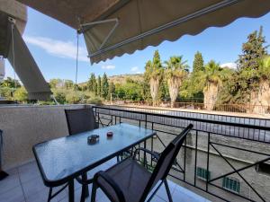 a table and chairs on a balcony with palm trees at GM Apartments in Tolo