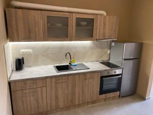 a kitchen with wooden cabinets and a sink and a refrigerator at Spitaki Luxury Home in Agia Triada