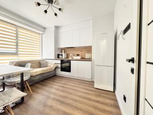 a kitchen and living room with a couch and a table at Комфортная квартира на Ботанике in Chişinău
